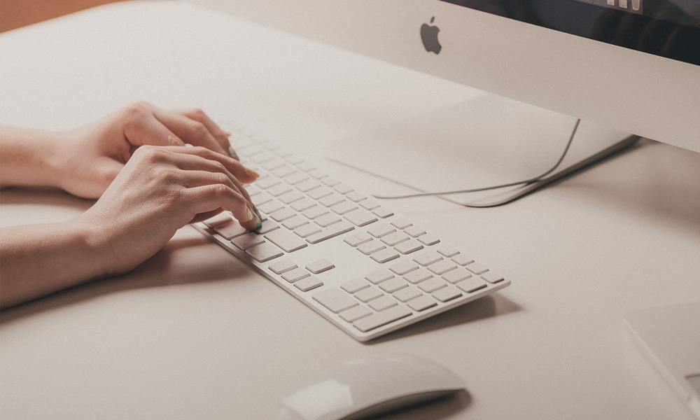Hands typing on computer